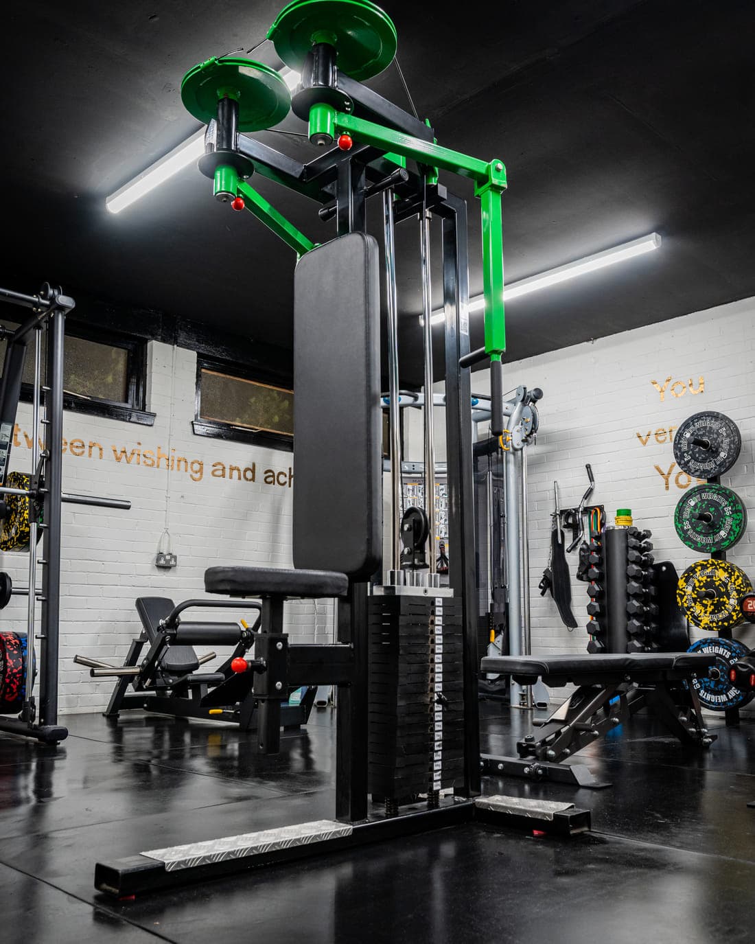 A selectorised resistance machine with a green frame and weight stack, part of the machine area at ODAAT Fitness